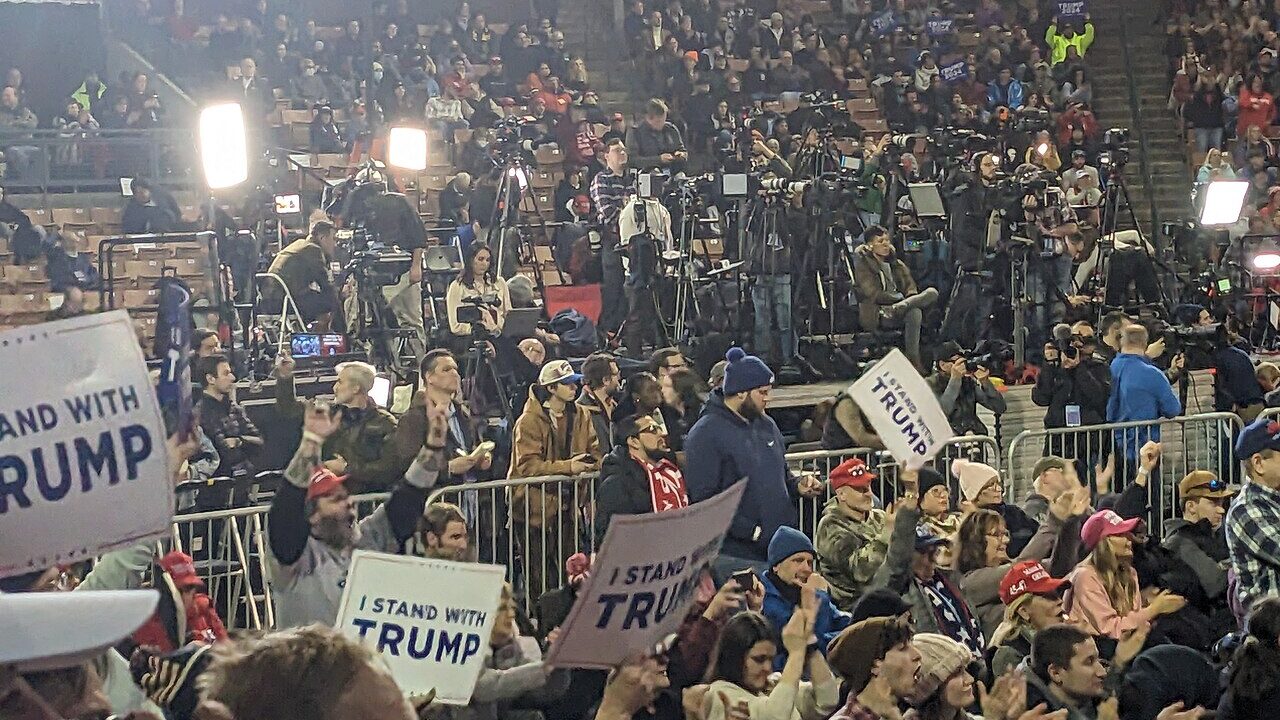 Crowd holding signs at a Donald Trump campaign rally in an arena
